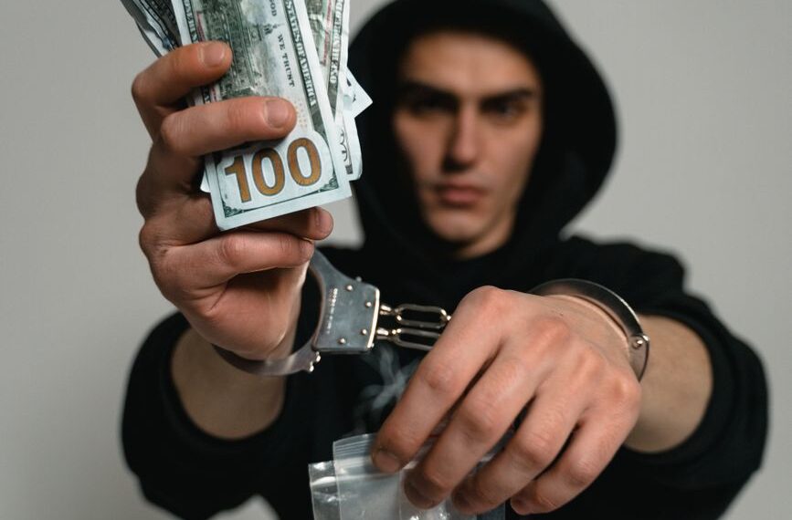 a man in handcuffs arrested for illegal drugs trade